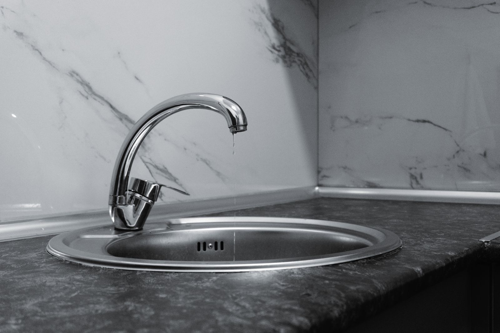 A modern chrome kitchen tap above a clean sink.